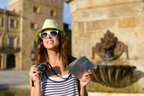 Female tourist with camera and guide map sightseeing